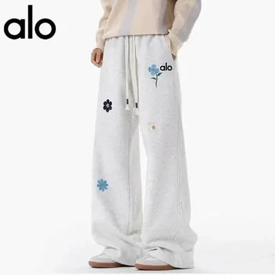Wide leg white sweatpants with small floral embroidery, worn with a cream sweatshirt
